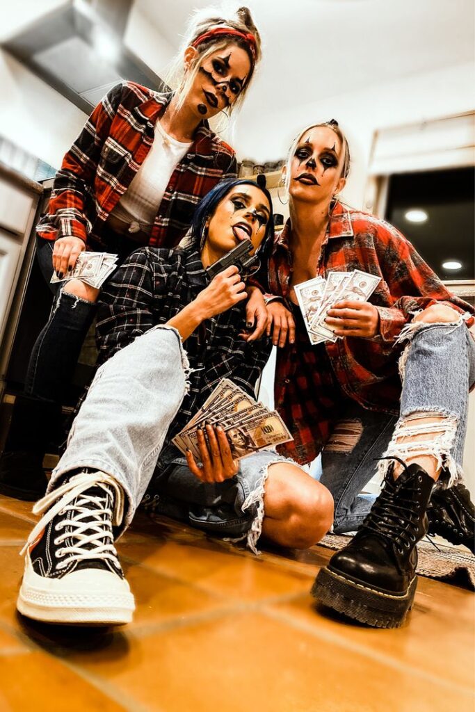 three gangster clowns posing with guns and money in kitchen